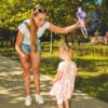 Mama in deklica lovita milne mehurčke na sončnem dnevu