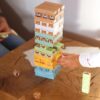Barvni stolp iz lesenih kock z motivi obrazov in živali – zabavna različica igre Jenga