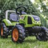 Otroški traktor Claas na travniku s podrobnostmi karoserije.