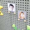Magnetni nosilci in fotografije otrok na perforirani plošči.